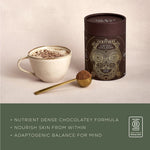 Cup of Ancient + Brave Cacao + Collagen hot chocolate beside the tub, a nutrient-dense chocolatey formula with adaptogens