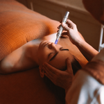 Therapist performing a microneedling facial treatment with a microneedling pen on a client relaxing on a treatment bed at Ara'kai Copenhagen