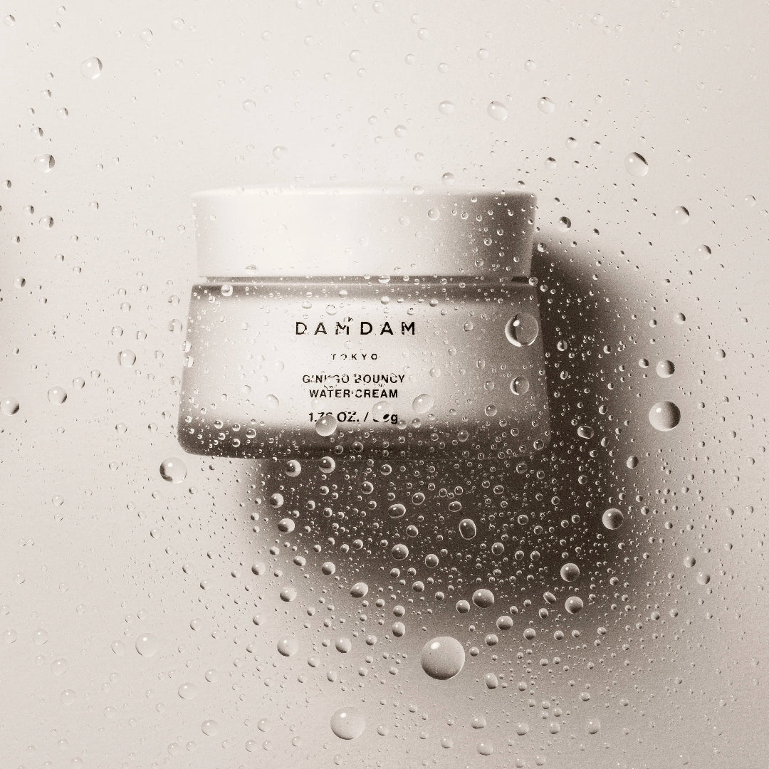 DAMDAM Ginkgo Bouncy Water Cream jar surrounded by water droplets for refreshing hydration
