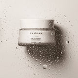 DAMDAM Ginkgo Bouncy Water Cream jar surrounded by water droplets for refreshing hydration