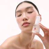 Model holding DAMDAM Ume Plum Firming Serum to her cheek