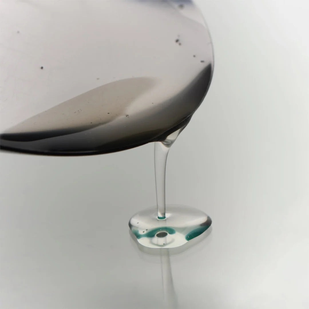 Clear, glassy texture of DAMDAM Ume Plum Firming Serum dripping from a spoon