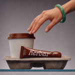 Hand reaching for Herbar The Lip Butter Mooncake in a takeaway tray beside a coffee cup
