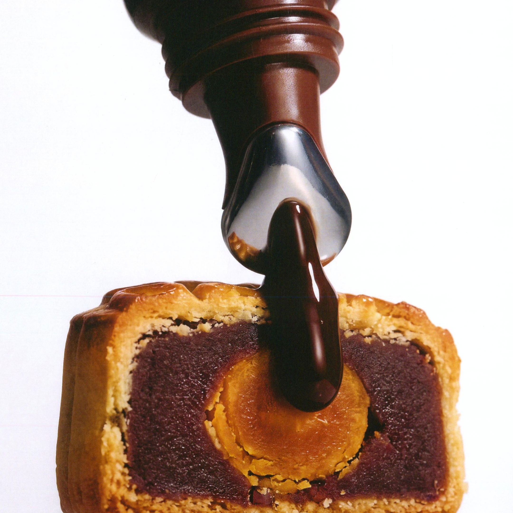 Herbar The Lip Butter Mooncake tube squeezing onto a red bean mooncake, the pastry that inspired its flavour