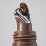 Brown buttery texture of Herbar The Lip Butter Mooncake swirling from the applicator tip