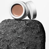 Open jar of Manasi 7 All Over Colour Manketti resting on a dark volcanic stone