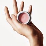 Hand holding a jar of Manasi 7 Strobelighter Sunsubiro organic cream highlighter