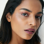 Model wearing Manasi 7 Strobelighter Sunsubiro as a pink highlighter on cheekbones and eyes
