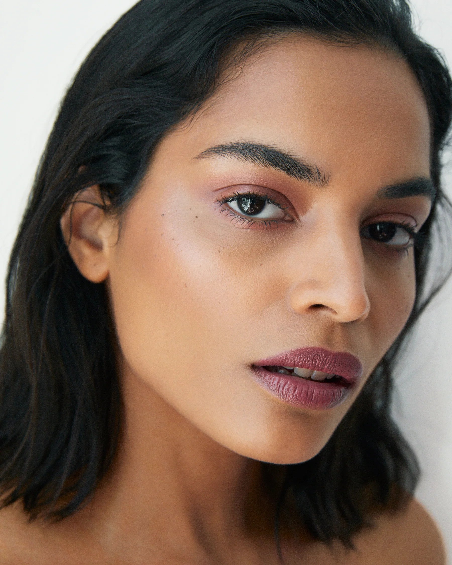 Model wearing Manasi 7 Strobelighter Sunsubiro as a pink highlighter on cheekbones and eyes