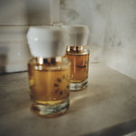 Two Porcelain No 1 Osmanth eau de parfum bottles with white porcelain caps on a stone mantelpiece