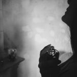 Black and white silhouette of a person spraying Porcelain No 2 Myristica natural eau de parfum onto the neck
