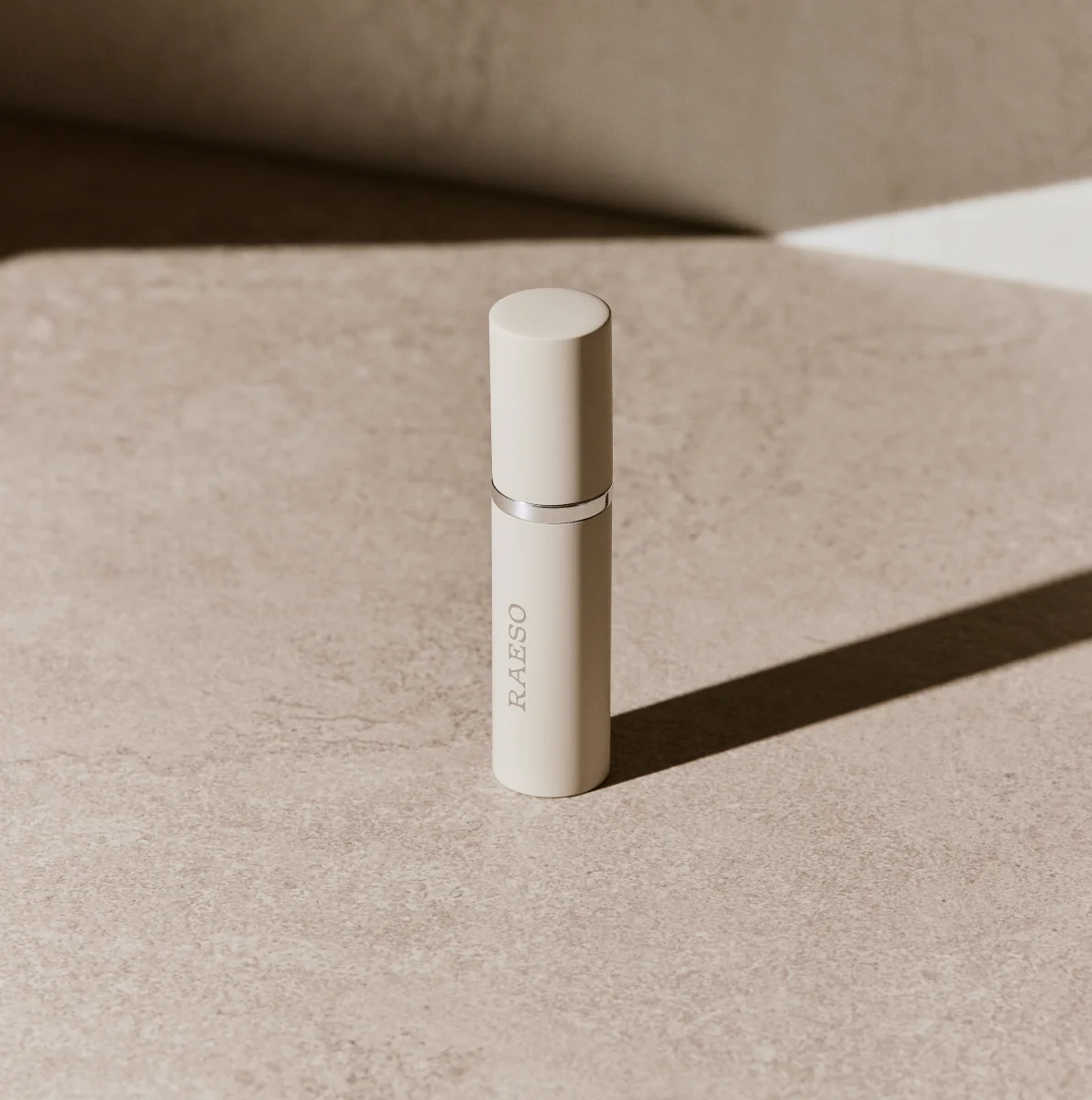 RAESO Golden Nectar Mānuka Honey Enzyme Cleanser mini on a stone surface in soft sunlight